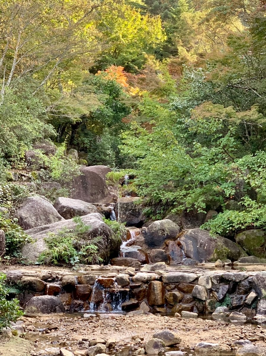 Waterfall and Japanese maples in Momijidani Park on Miyajima Island
