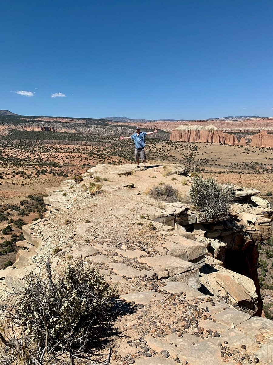 Standing an a narrow plateau outcropping looking out over Cathedral Valley in Capitol Reef National Park