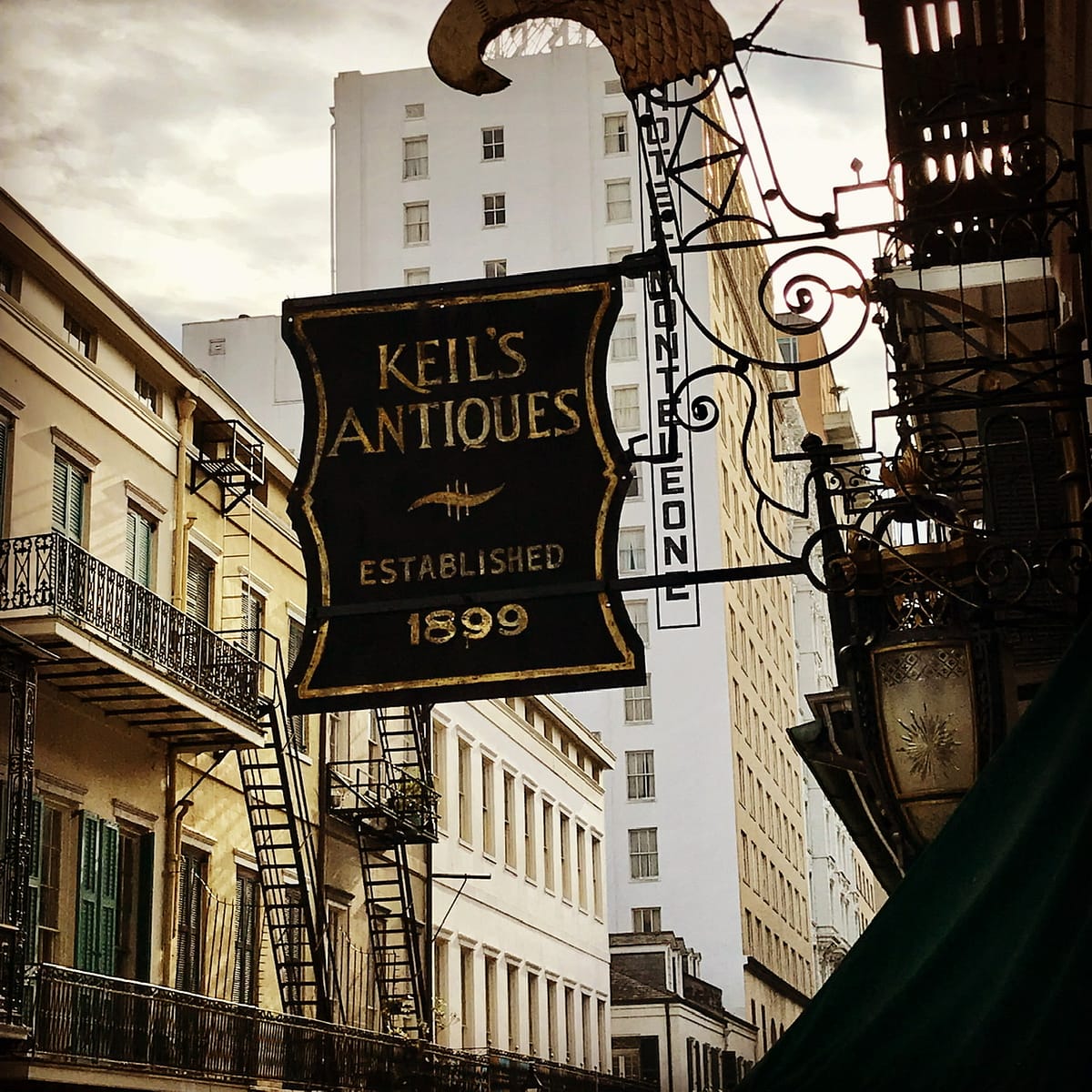 Antique sign with Hotel Monteleone in the distance in the French Quarter in New Orleans