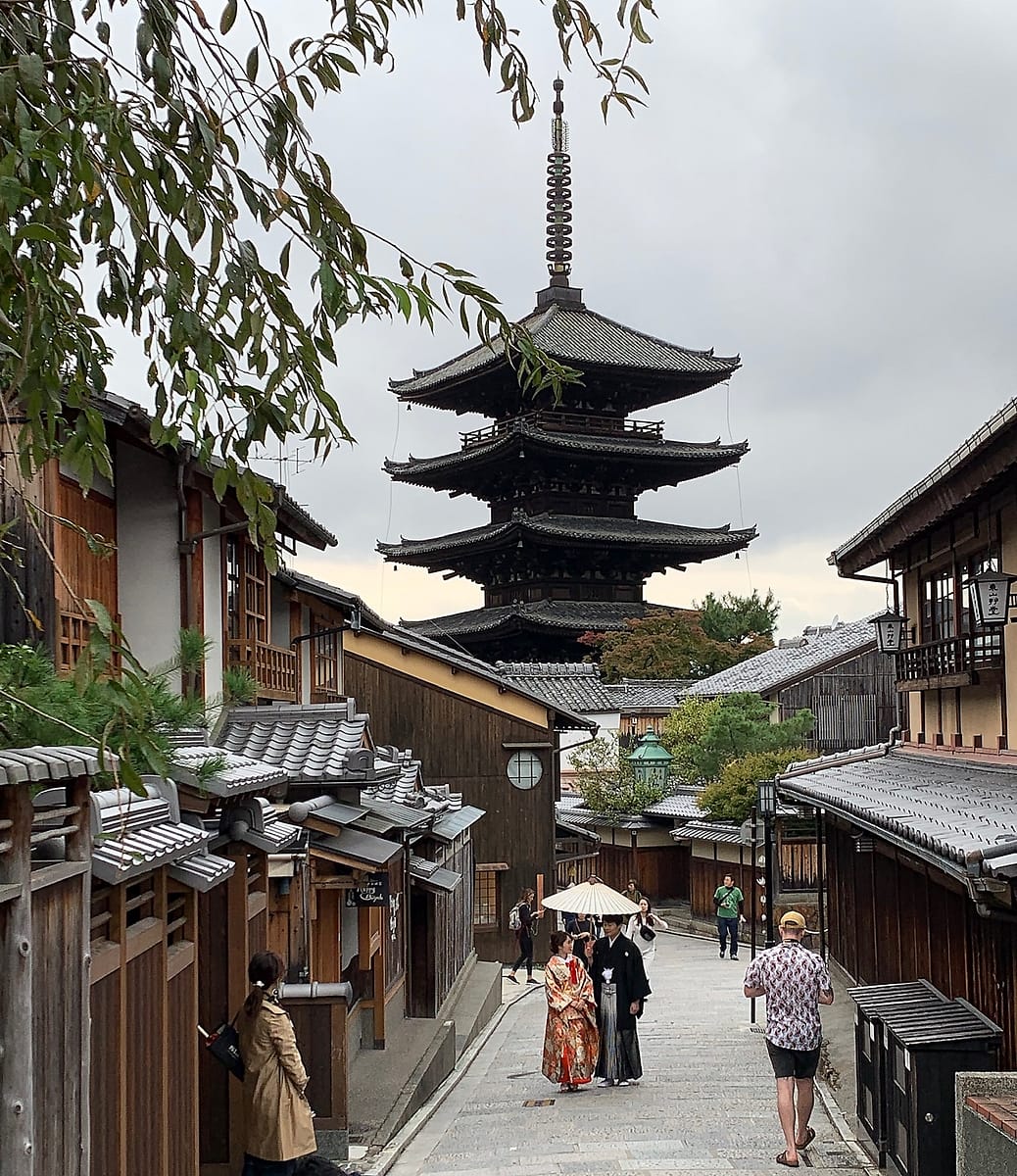 A pagoda in the Higashiyama District of Kyoto Japan with a bride and groom in the foreground