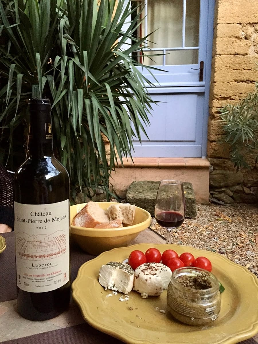 A simple meal in Lourmarin France of wine, goat cheese, tampanade, and bread.