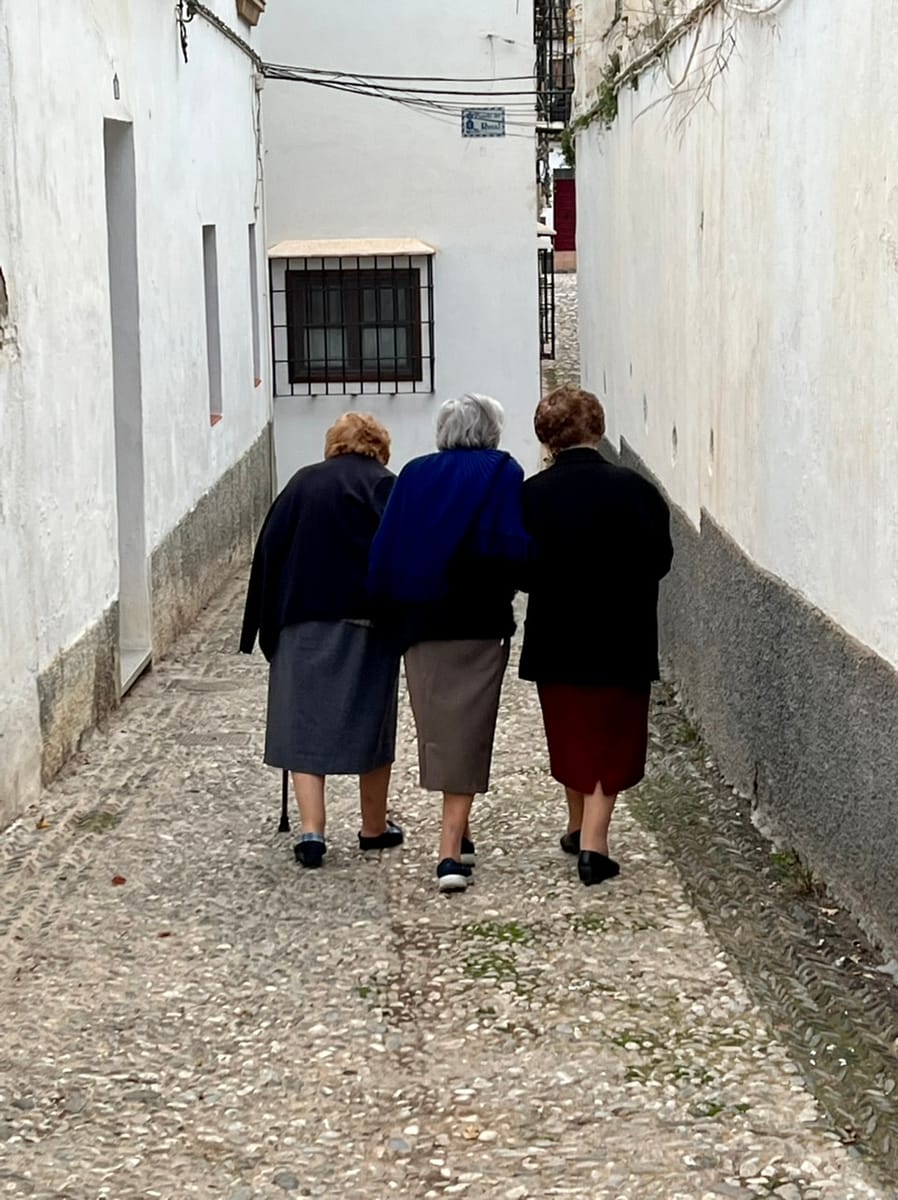 Three old women walking down a street in Granada's Albaicin district