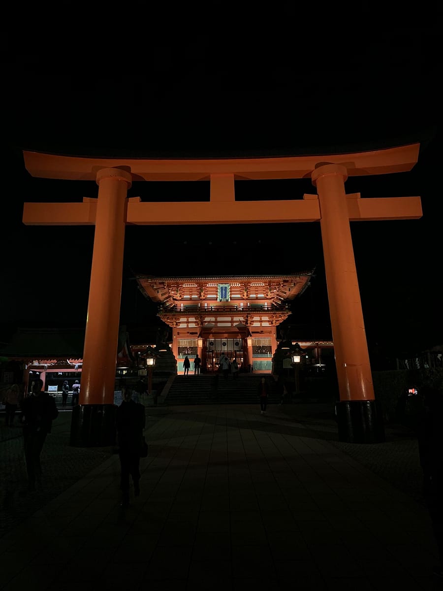 The glowing shrines of Fushimi Inari at night in Kyoto Japan